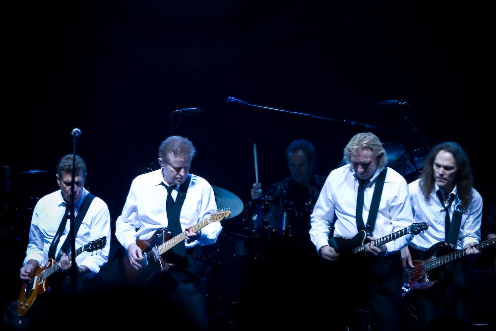 dark image of members of the Eagles on stage