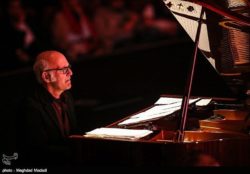 Ludovico Einaudi on piano in red hue
