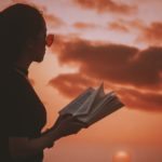 Woman reading book against sunset -#MeToo article