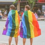 two women with LGBTQ+ flag