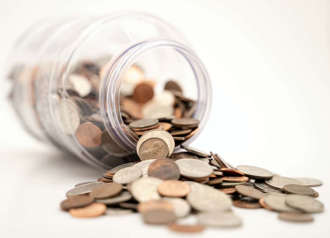 Jar filled with money, tipped over / Image: Unsplash