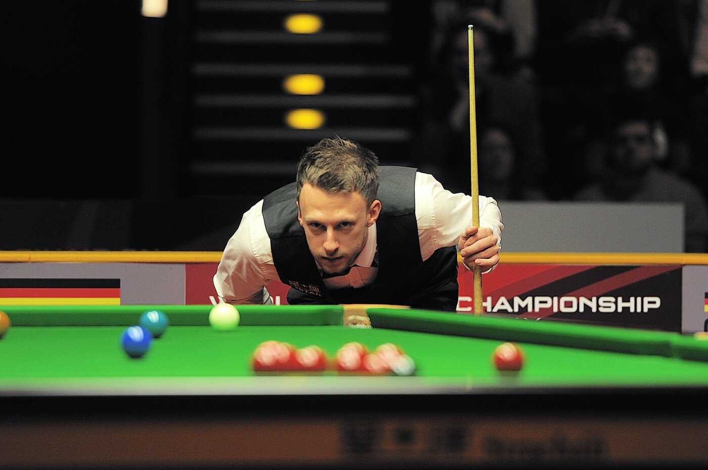Judd Trump leaning over the table at the 2014 German Masters