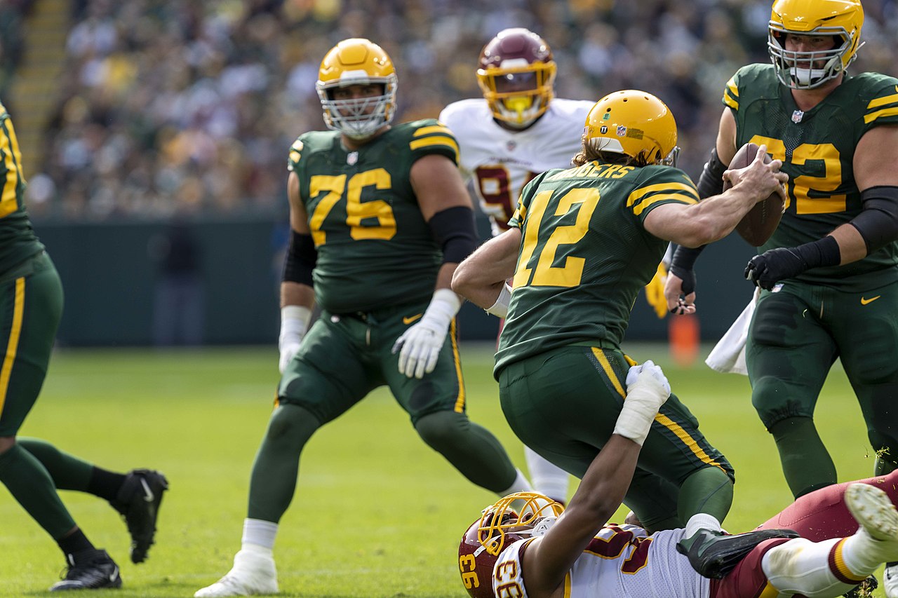 Aaron Rodgers being dragged down by a tackle