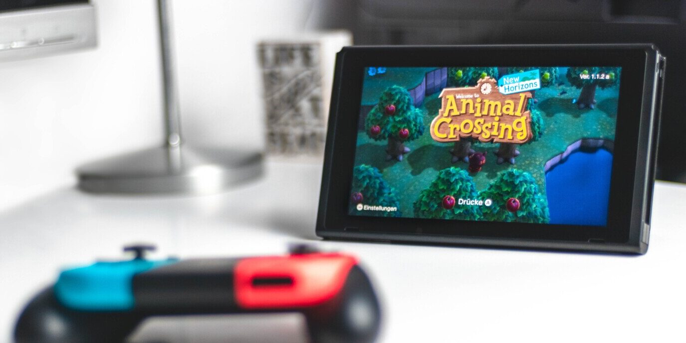 Nintendo Switch controller sitting by a Switch screen displaying the Animal Crossing opening screen
