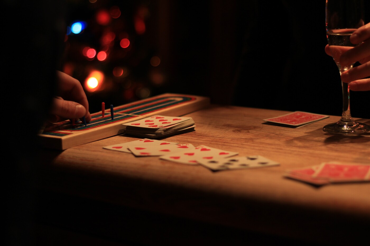 people playing cards and games in front of a christmas tree