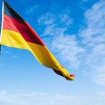 Germany's flag waving against a blue sky backdrop