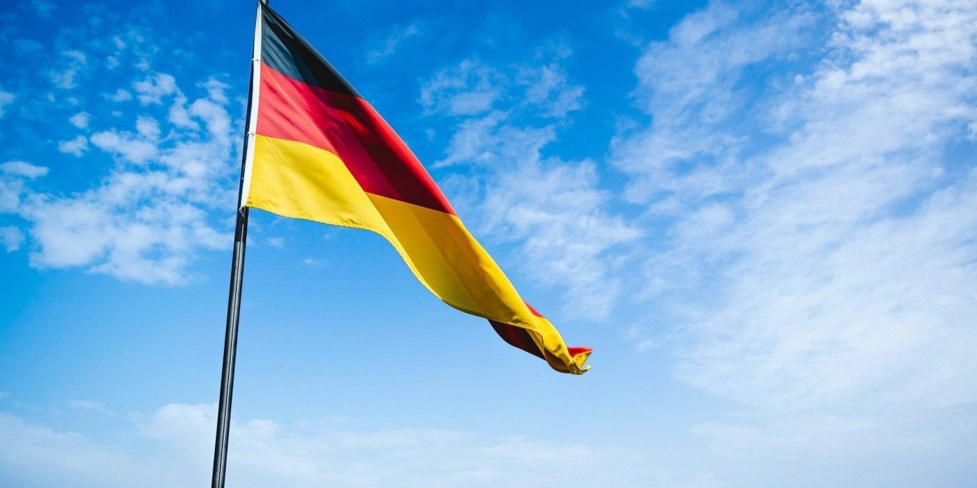 Germany's flag waving against a blue sky backdrop