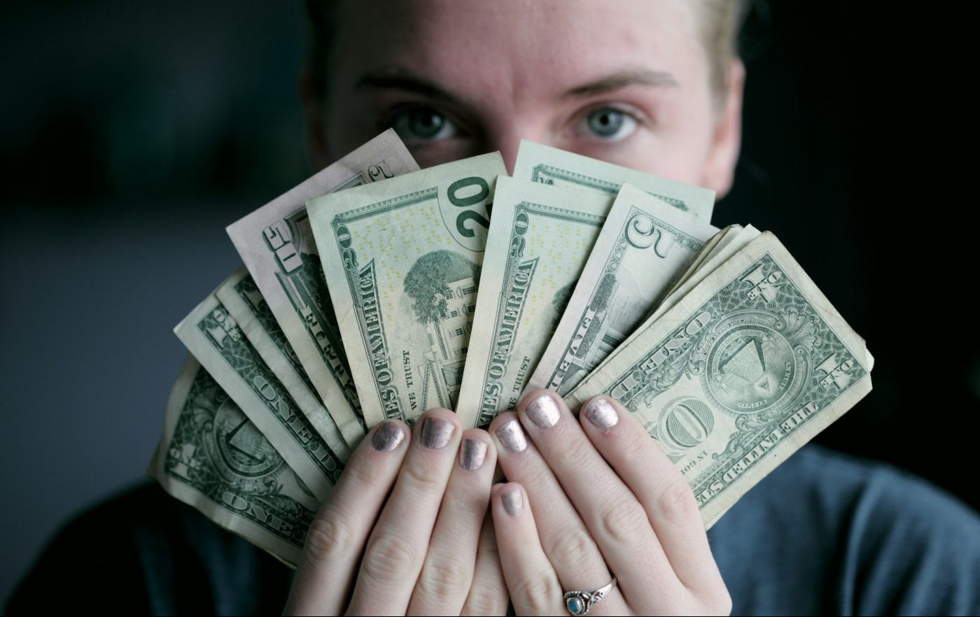 A man holding a wad of cash.