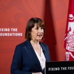 UK Chancellor Rachel Reeves giving a speech. Text saying "Fixing the Foundations" is enscribed on her lectern and the red background behind her.