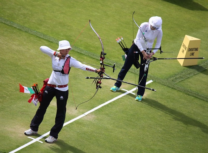 Two women holding bows and arrows