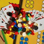 A cluster of cards and board game pieces together on a table