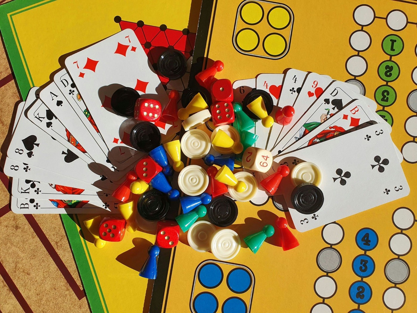 A cluster of cards and board game pieces together on a table