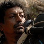 A focused male director in front of a camera