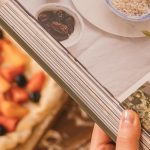 Picture of a woman holding a cookbook with a pie in the background