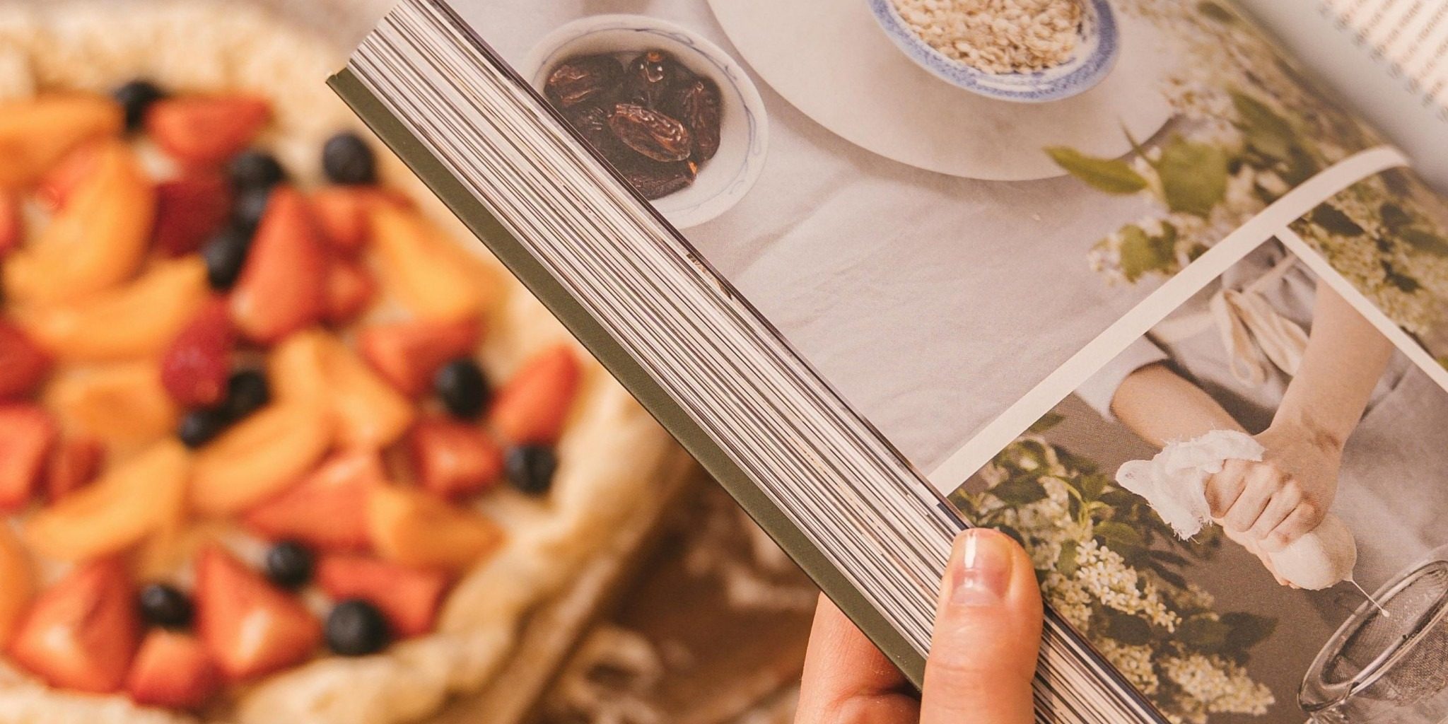 Picture of a woman holding a cookbook with a pie in the background