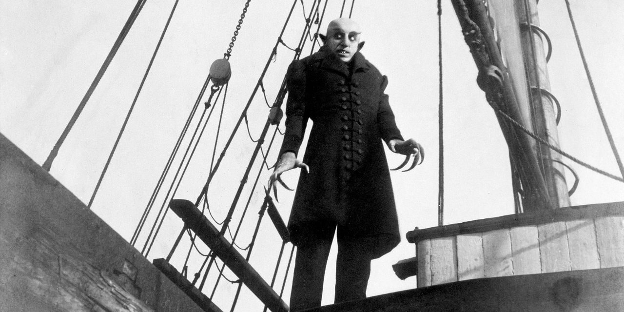A still of the vampire Nosferatu from the 1922 silent film looking ominous aboard a boat