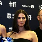 A red carpet photo of two female Norwegian actors with their film's director
