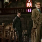 A detective and priest stand in the aisle of a grand church