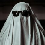 Person Under a White Blanket Wearing Sunglasses