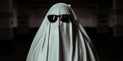 Person Under a White Blanket Wearing Sunglasses
