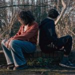 Two people back to back in a forest