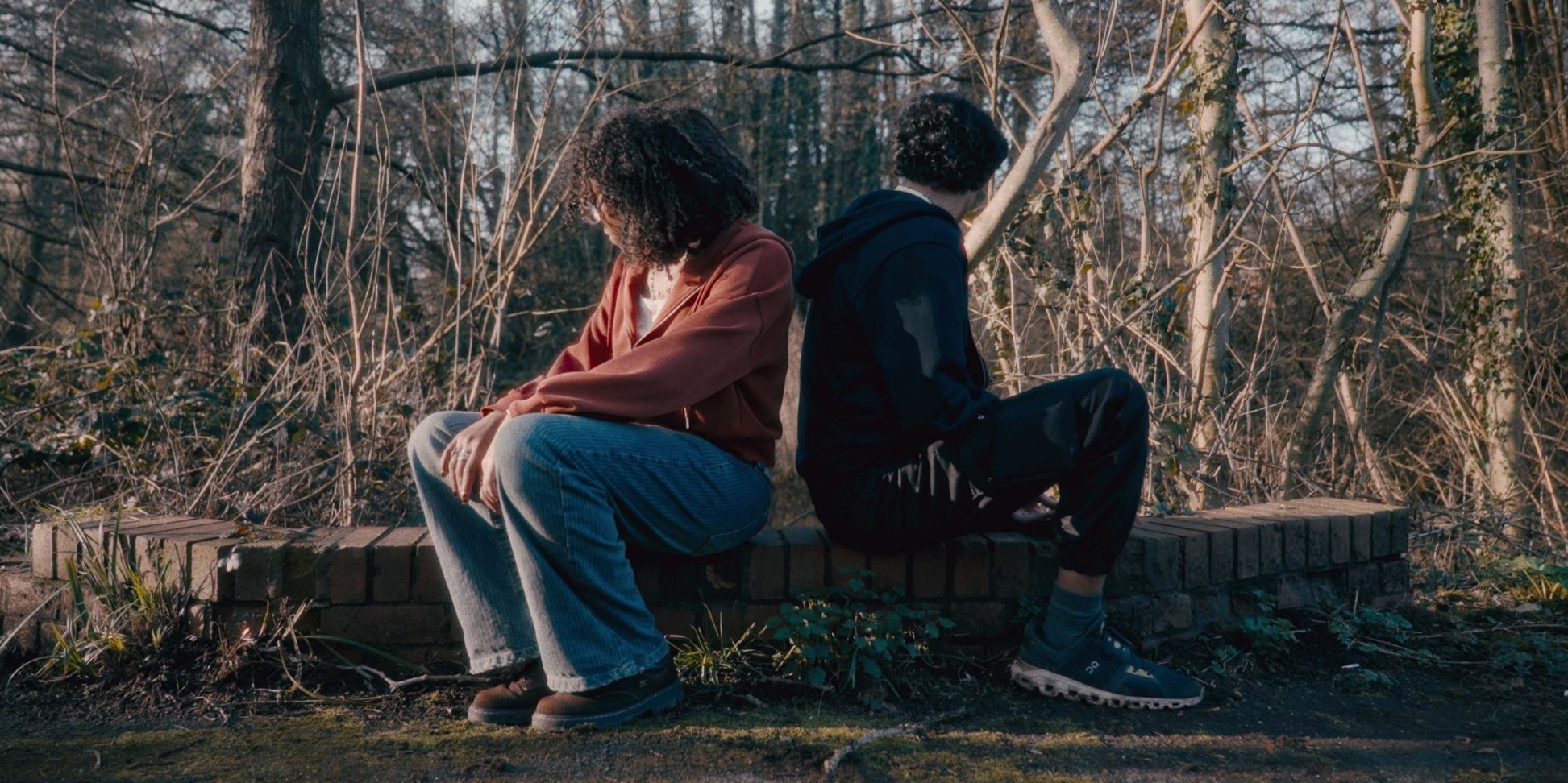 Two people back to back in a forest