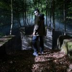 Masked figure in forest